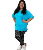 WOMAN WEARING TEAL SHIRT WITH LEGGINGS