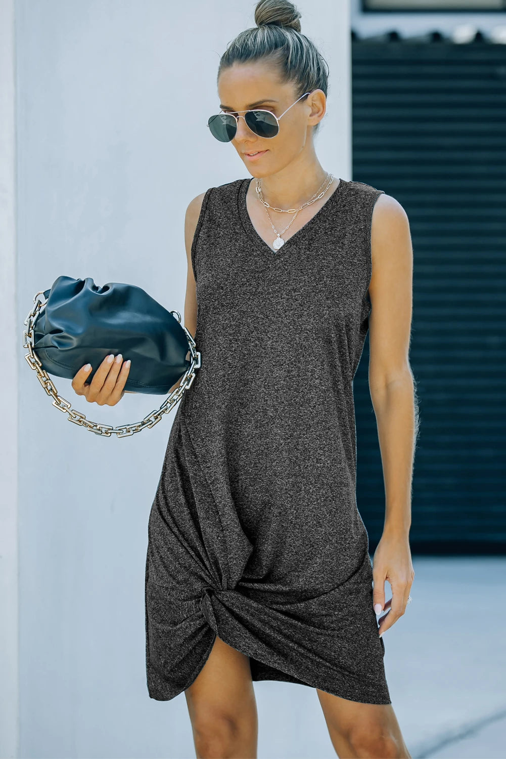 WOMAN WEARING BLACK DRESS WITH SIDE TWIST