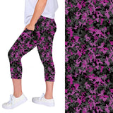 WOMAN WEARING PLUS SIZE BLACK AND PURPLE LEGGING CAPRIS