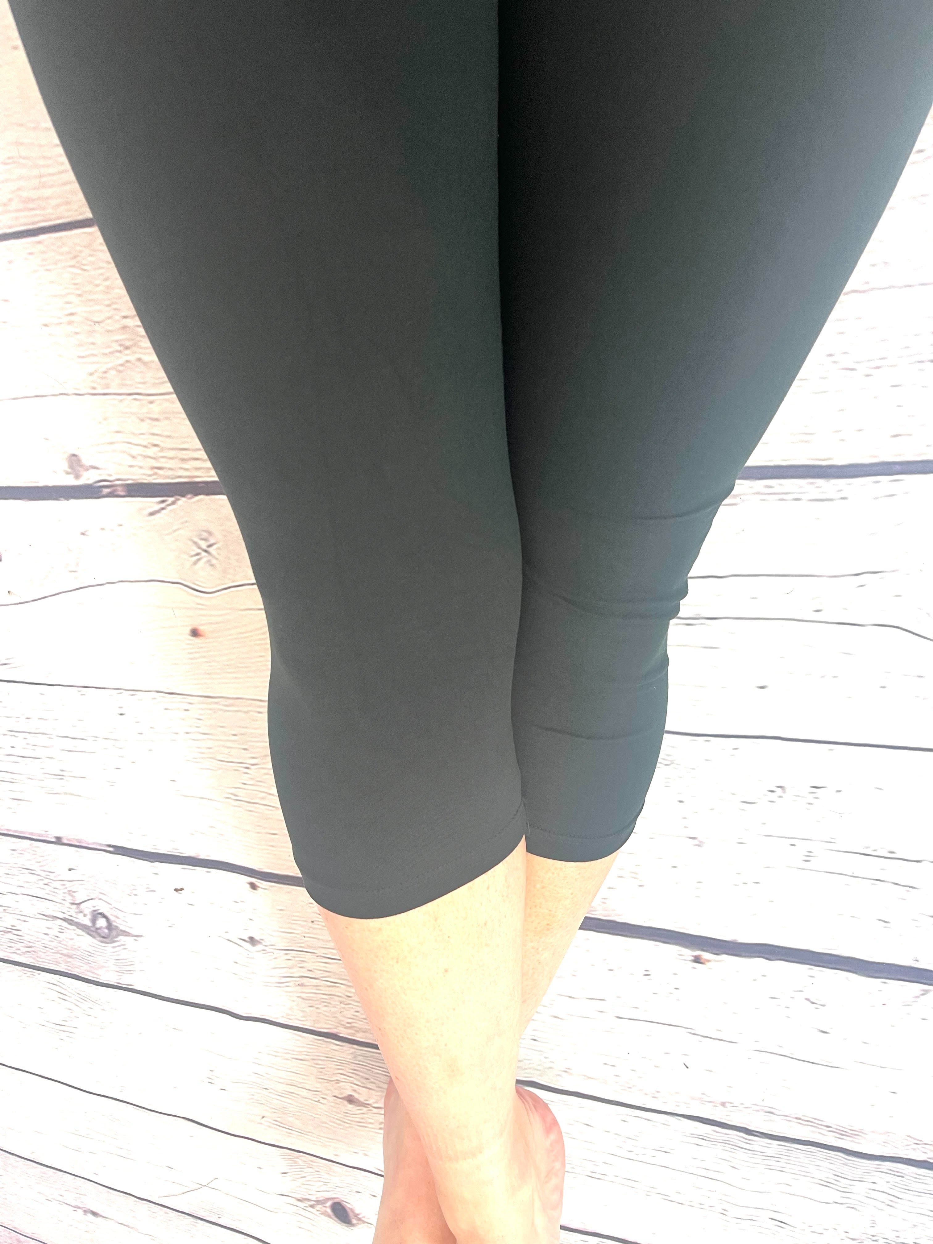 Woman wearing one size black yoga band capri leggings