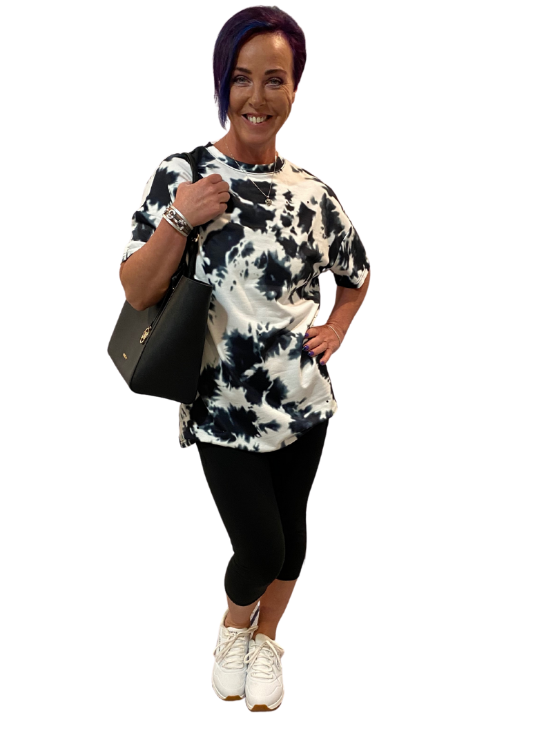 WOMAN WEARING A PATTERNED TOP AND BLACK CAPRIS