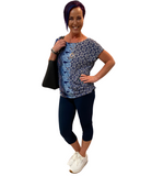 WOMAN WEARING A PATTERNED TOP WITH NAVY CAPRIS